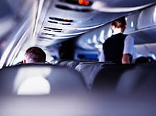 Airplane cabin with flight attendant facing away