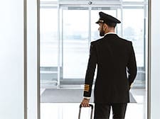 Pilot with suitcase walking out of the airport